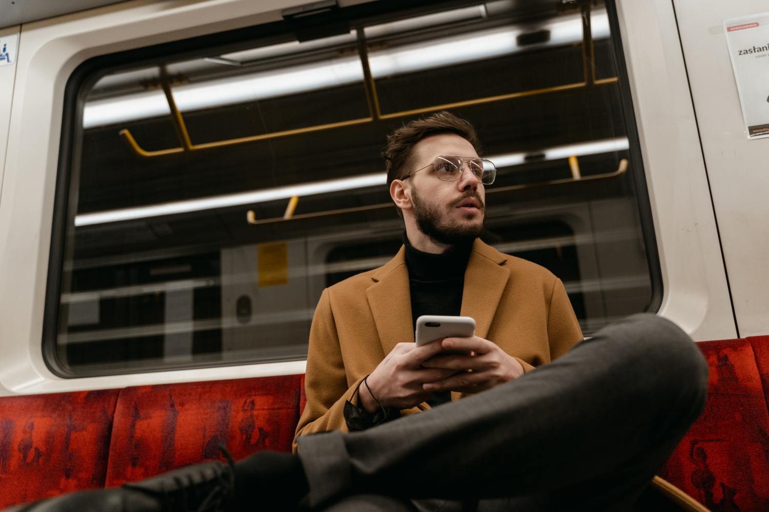 Man on train reading about how to write a letter of instruction on his phone.