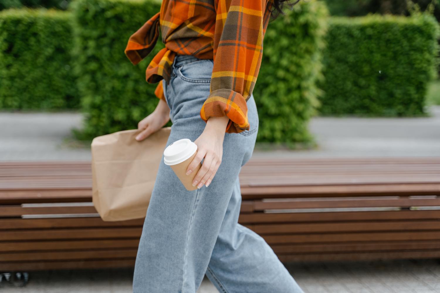 Woman walking with coffee in hand, thinking about the difference between tenancy in common vs joint tenancy.