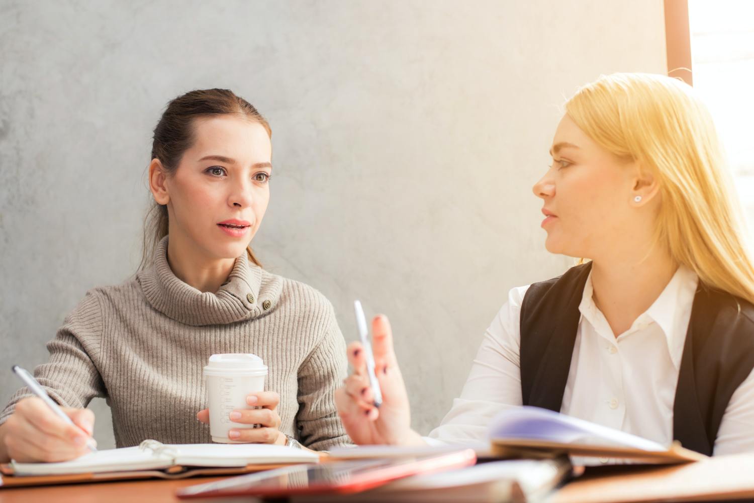 Two women discussing the testator of a will definition and responsibilities.